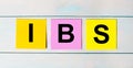 There are bright multi-colored stickers with the text IBS Irritable Bowel Syndrome. Copy space