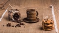 There is a coffee cup with a saucer made of coconut palm wood on rough burlap. From glass jar chaotically scattered Royalty Free Stock Photo