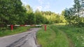 There is a dirt road from the asphalt highway into the forest. The metal barrier at the entrance to the forest is closed during dr Royalty Free Stock Photo