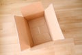 There is an empty open cardboard box on the floor, concept of mailing, package, online shopping, waste paper, renewable product,