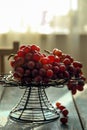 There are fresh grapes on the blue wooden table on the iron flower rack