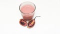 There is a glass of tamarillo juice and half a tamarillo on a white background. Royalty Free Stock Photo