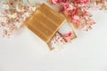 There Gold Open Box with White and Pink Branches of Chestnut Tree are on White Table,Top View.Toned