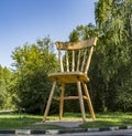 There is a huge wooden chair on the outskirts of the city