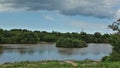 There is an islet in the lake, overgrown with green bushes.