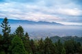 There are layers of white clouds floating over the valley villages.