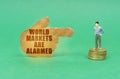 There is a little man on the coins, a hand with the inscription points to him - World markets are alarmed Royalty Free Stock Photo