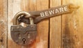 There is a lock on the door on the metal part of which it is written - BEWARE Royalty Free Stock Photo