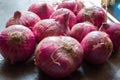 There are a lot of onions lying on the slab of a kitchen with selected focus