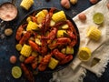 There are many ingredients in the photo - lemons, pieces of corn, boiled crayfish and pieces of boiled corn on a white background