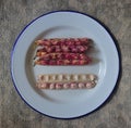 Few whole cranberry bean with one cut into halves open with the beans exposed on blue enamelware plate Royalty Free Stock Photo