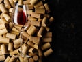 There are many wine corks and a glass of red wine on a black background. Stylish composition. No people. Restaurant, hotel, wine Royalty Free Stock Photo