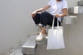 Model hold blank white fabric tote bag for save environment on street fashion with white t-shirt