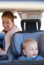 Are we there yet Mom. a mother sitting in a car with her baby boy in a car seat. Royalty Free Stock Photo