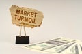 There is money on the table, next to it is a cardboard sign with the inscription - market turmoil