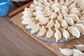 There are neatly wrapped dumplings on a circular tray in the kitchen