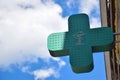 There is a neon green cross-shaped sign on the wall advertising a pharmacy or hospital. There is a place on the left to Royalty Free Stock Photo