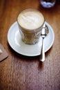 There is a cup of latte on the table of a coffee shop