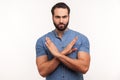 There is no way. Strict bossy bearded man in blue shirt showing x gesture with hands, rejection sign, warning about wrong way