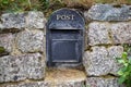 There is an old English metal mailbox built into the stone wall