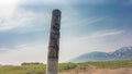 There is an old weathered wooden idol in the valley.