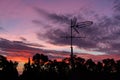 There is a black metallic television antenna and a group of black trees on the beautiful red colorful sunset sky background Royalty Free Stock Photo