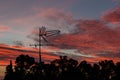 There is a black metallic television antenna and a group of black trees on the beautiful red colorful sunset sky background Royalty Free Stock Photo