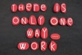 There is only one way, work, creative quote composed with red colored stone letters over black volcanic sand Royalty Free Stock Photo