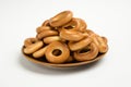 There is a pile of bagels on a saucer on a white background for clipping