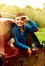 Are we there yet. Portrait of an adorable little boy leaning out of a car window outside. Royalty Free Stock Photo