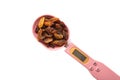 There are raisins on the electronic measuring spoon. Wide LCD screen. White background Royalty Free Stock Photo