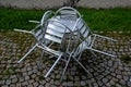 There are reclining chairs folded around the round table. stainless steel polished tables in front of a cafe wet from rain and dew Royalty Free Stock Photo