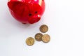 There is a red piggy bank on a light table, next to it are several Russian coins. View from above. Money accumulation concept, Royalty Free Stock Photo