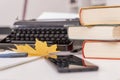 Workplace of modern writer with old typewriter, books, notebook and pen, telephone. Autumn mood. Royalty Free Stock Photo