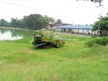 There is a rice cutting machine  standing on the bank of a pond Royalty Free Stock Photo