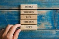 While there`s life there`s hope sign written on five stacked wooden pegs Royalty Free Stock Photo