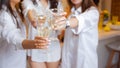 There`s toast. A group of female friends in white shirts clink glasses with champagne. Royalty Free Stock Photo