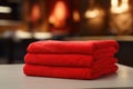 There is a set of red terry towels on the shelf