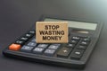 There is a sign on the calculator that says - Stop Wasting Money Royalty Free Stock Photo