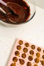 There is a silicone mold filled with chocolate mixture on the table. Making chocolates