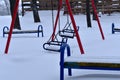 There is snow on the children's swing on metal chains. Royalty Free Stock Photo