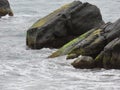 Ocean waves and some bubble on the surface, rocks or riff on the side.