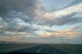 Highway with Wind turbines at sunset with beautiful clouds Royalty Free Stock Photo