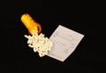 Spilled prescription pills on a prescription pad on a black background Royalty Free Stock Photo