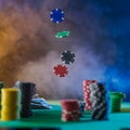 There are stacks of multi-colored chips on the green gambling table. Chips are also in the air. Levitation. Multicolored smoky Royalty Free Stock Photo