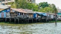 Wooden Water Houses Along The Riverside On The Chao Phraya River In Bangkok, Thailand