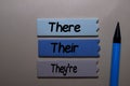 There, Their, They`re write on a sticky note isolated on office desk. Learning use proper grammar