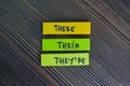 There, Their and They`re write on sticky notes isolated on Wooden Table