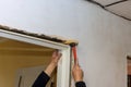 There of a trim worker using a hammer during the installation of interior doors inside a new house Royalty Free Stock Photo