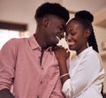 There truly soulmates. an affectionate young couple smiling at each other in their kitchen at home.